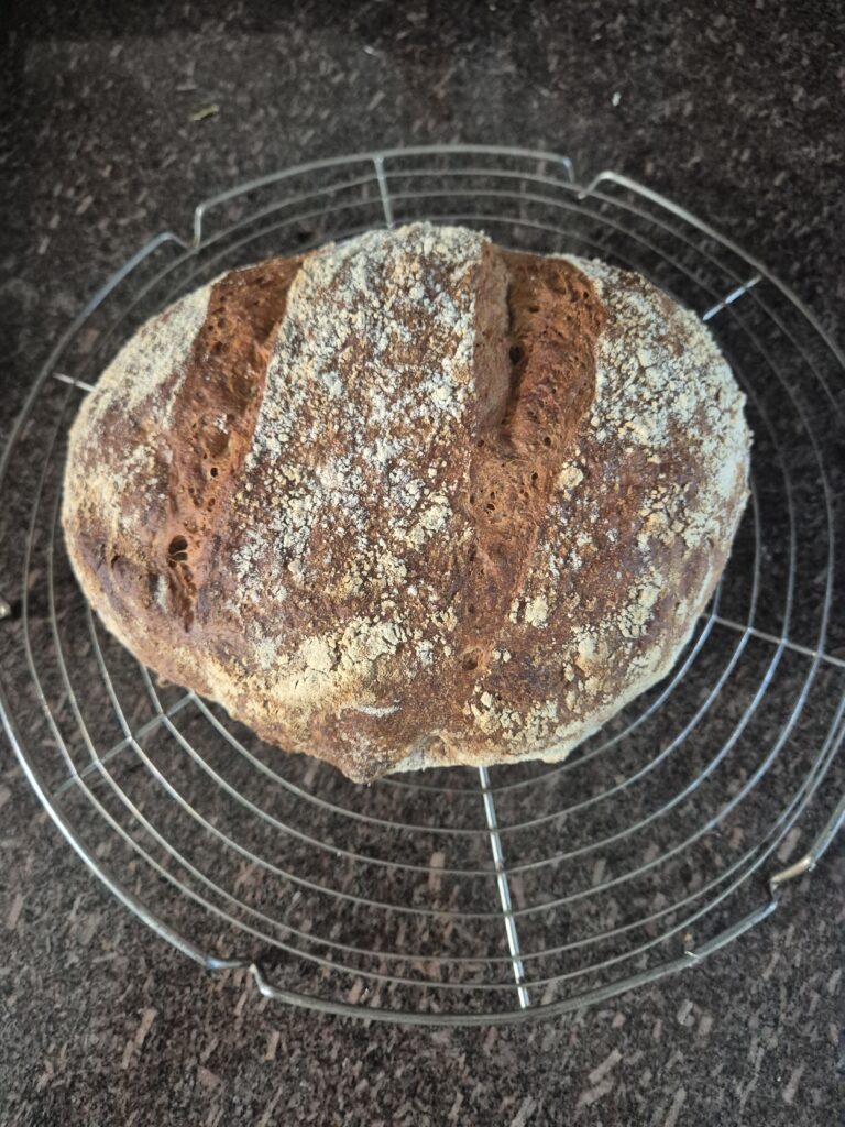 How to make sourdough bread at home – freshly baked crusty sourdough loaf cooling on rack