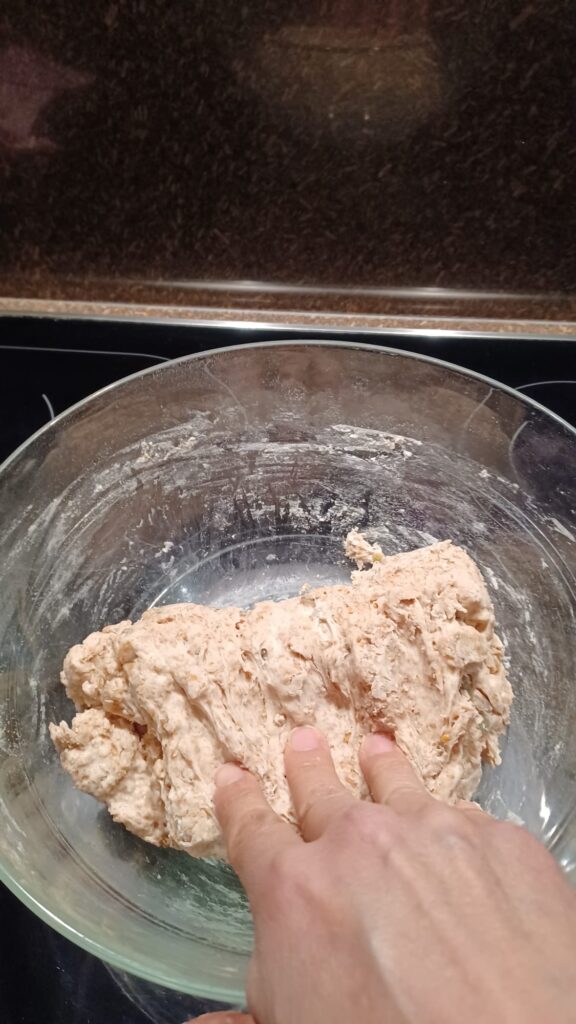 Folding sourdough dough over itself during the stretch and fold process