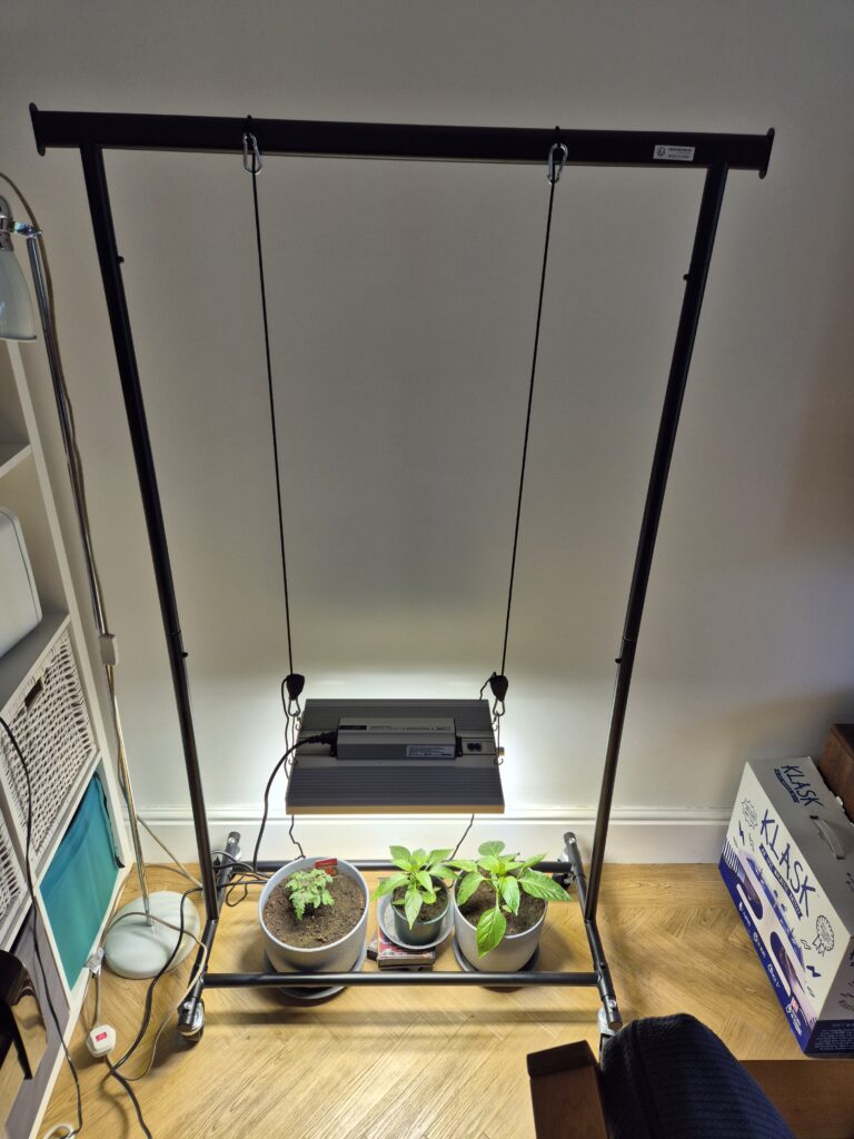 ViparSpectra XS1500 Pro LED grow light hanging from clothes rack in indoor setup