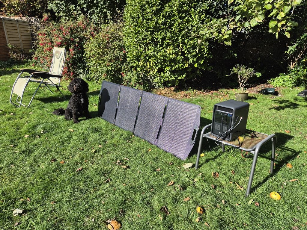 Portable solar panel setup with backup power system in garden.